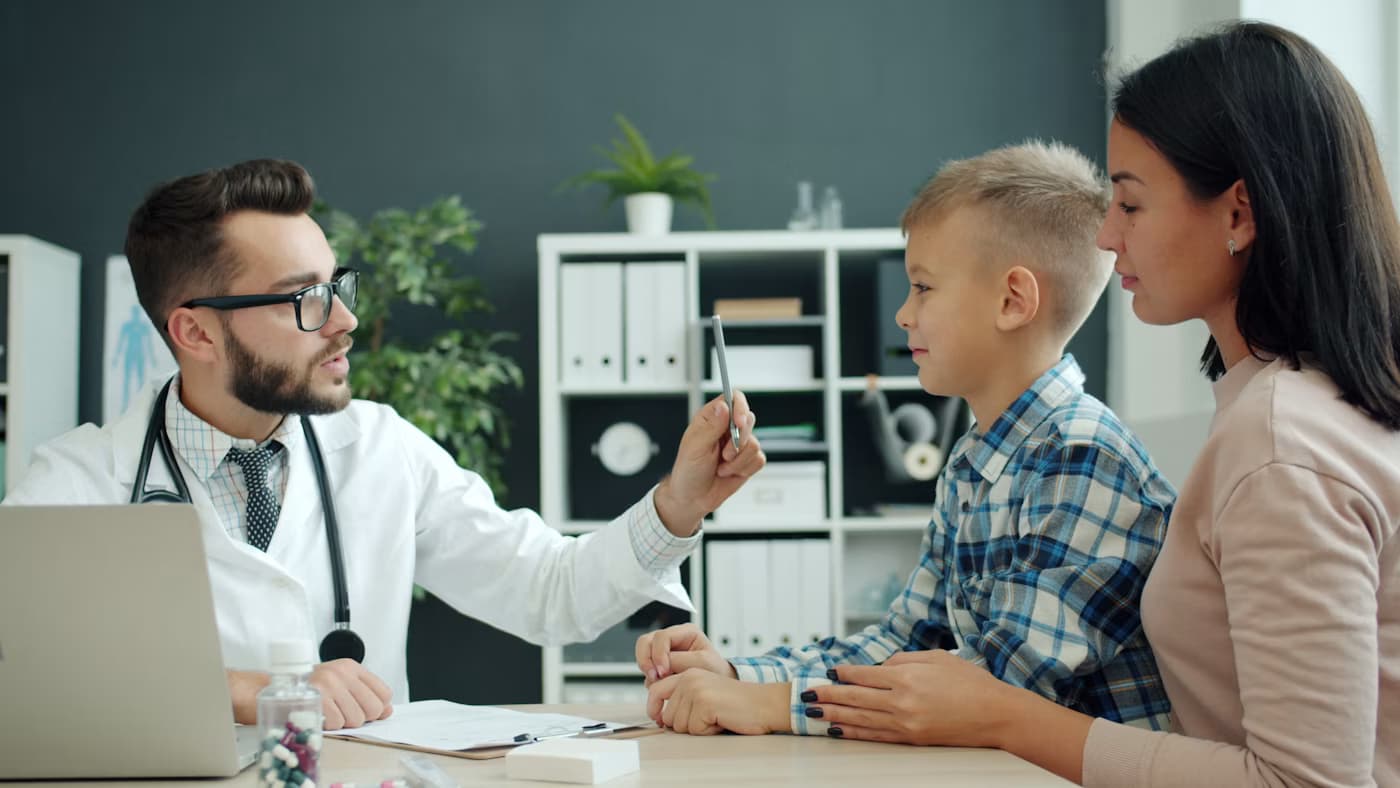 A pediatrician talking with a parent and child during an appointment