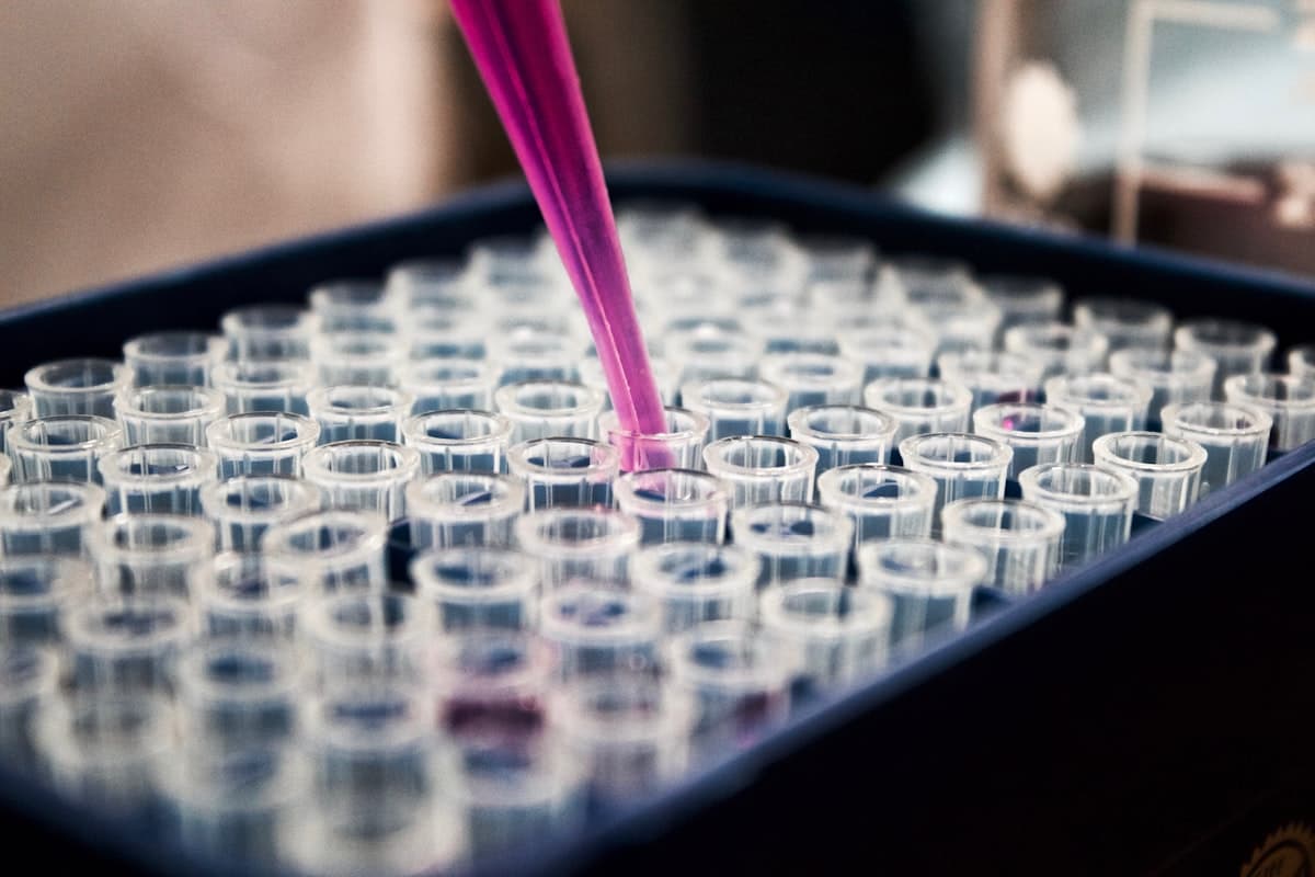 A pipette dispensing liquid into laboratory test tubes